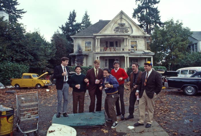 a group of men standing outside of a house