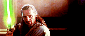 Qui-Gon holding a lightsaber, ready for a fight