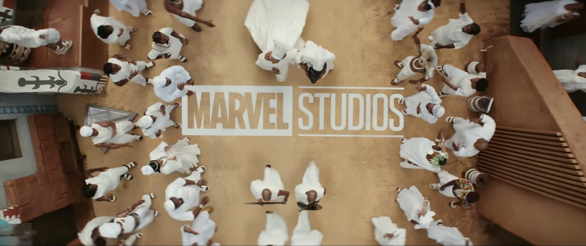 An overhead shot of the all-white procession featuring the Marvel Studios logo, also in white