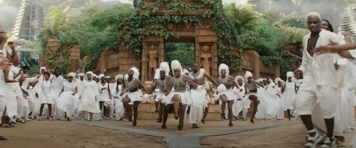 In a scene from the trailer, dancers perform in the middle of a square while onlookers celebrate with them; the dancers and crowd are all wearing nothing but white clothes