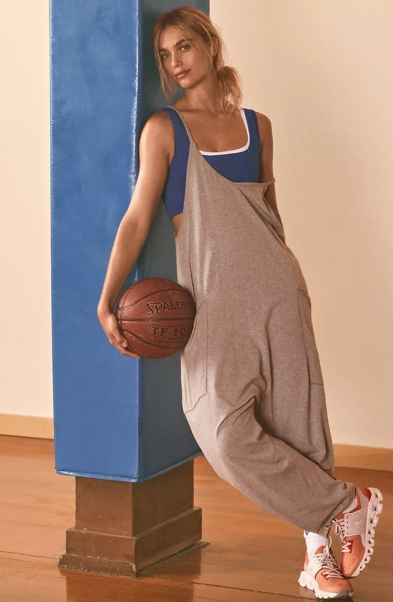 Model holding basketball wearing gray hot shot onesie over blue tank