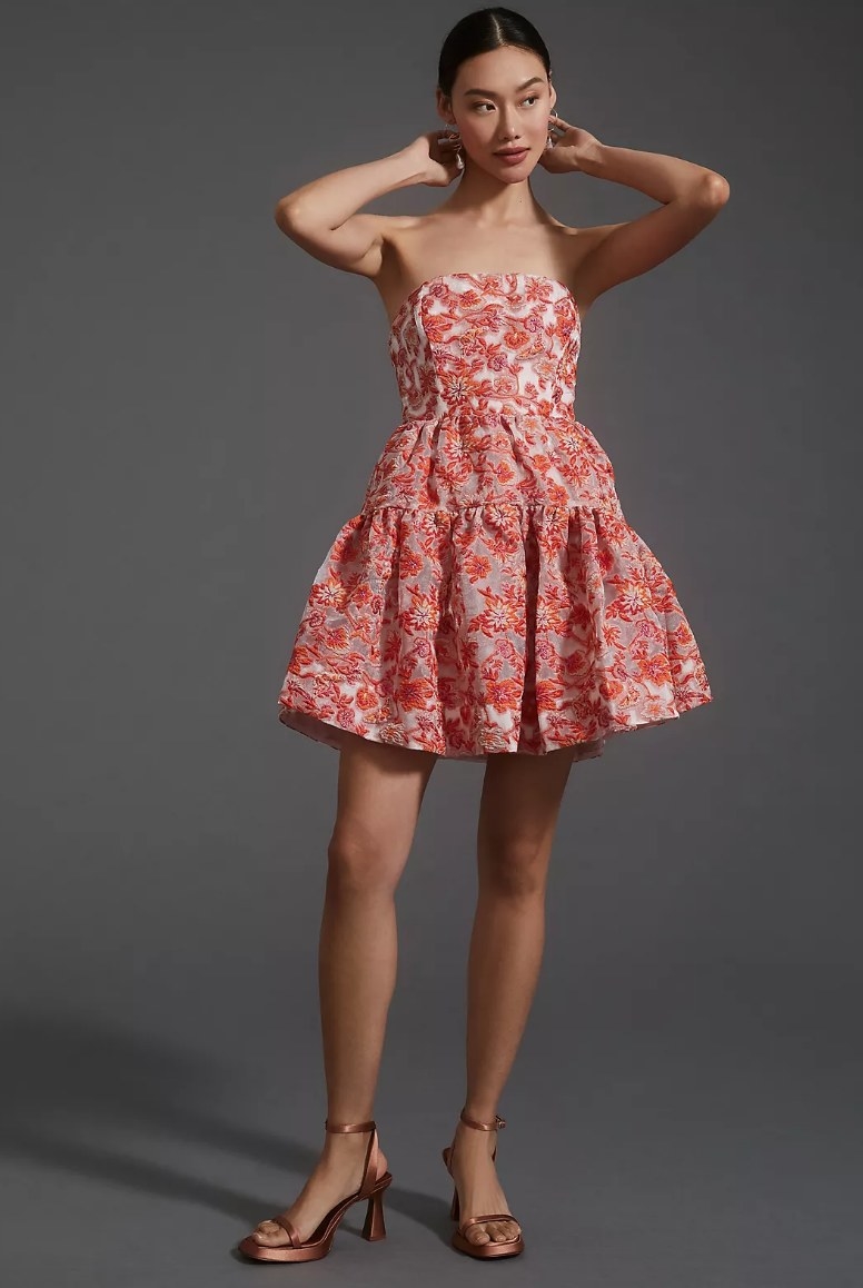 Model wearing pink floral strapless mini dress