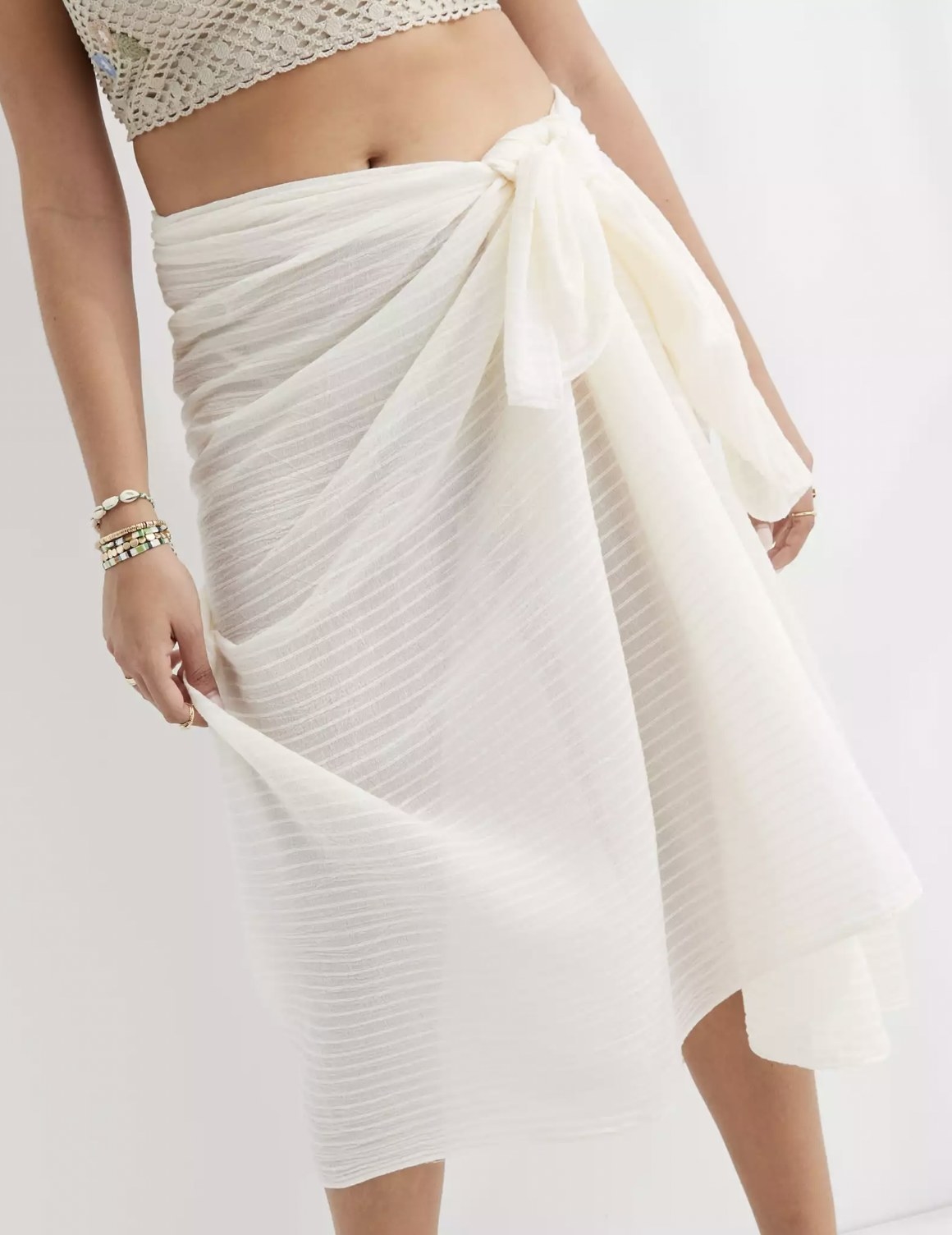 Model wearing the white striped muslin sarong tied at waist