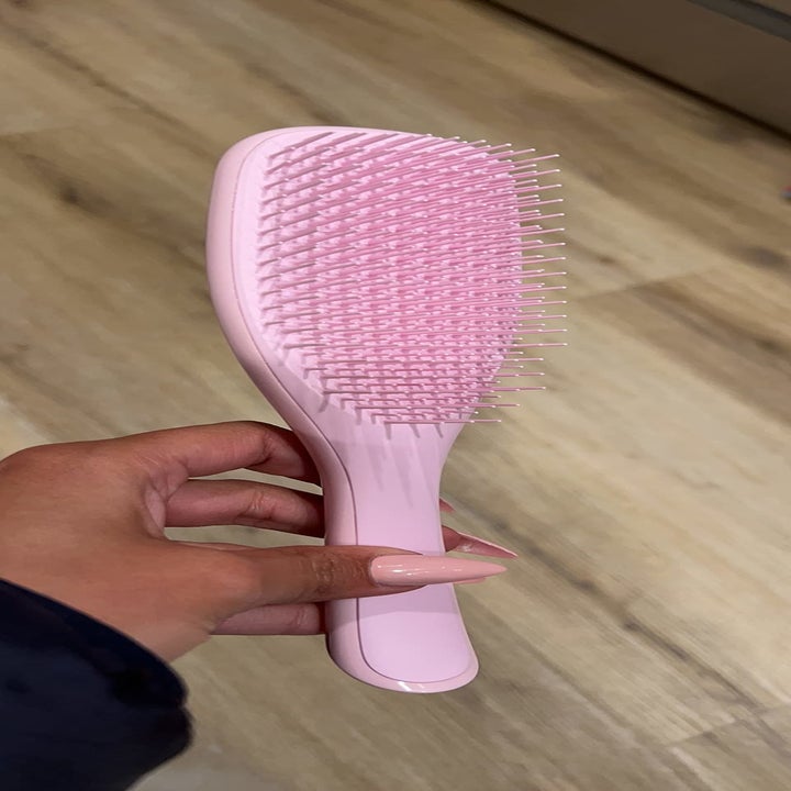 a reviewer holding their brush in pink