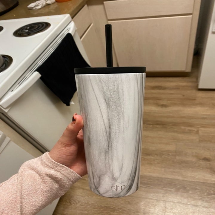 a reviewer holding their tumbler in marble