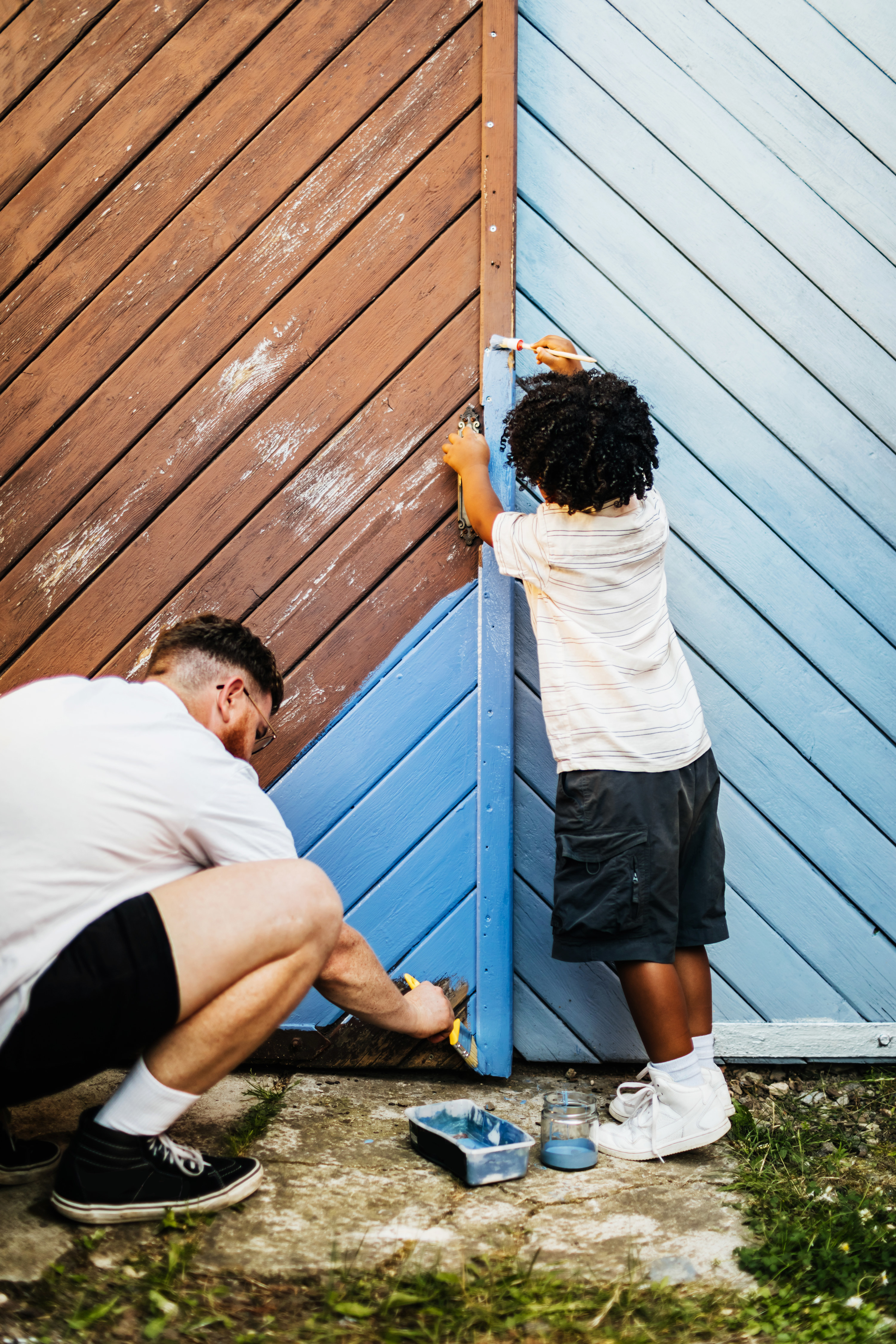 father and son painting a fence together