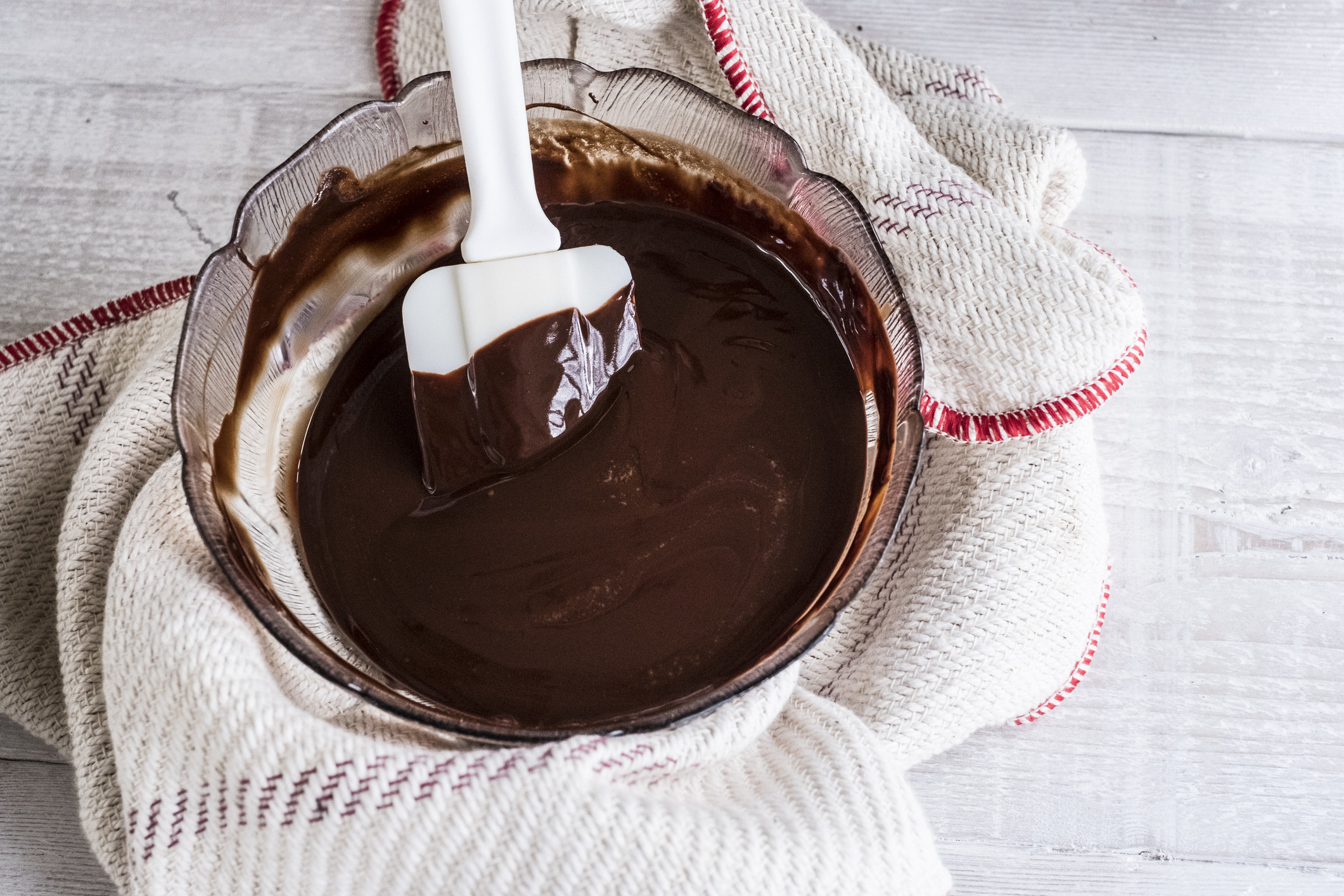 A bowl of chocolate brownie ingredients being stirred.
