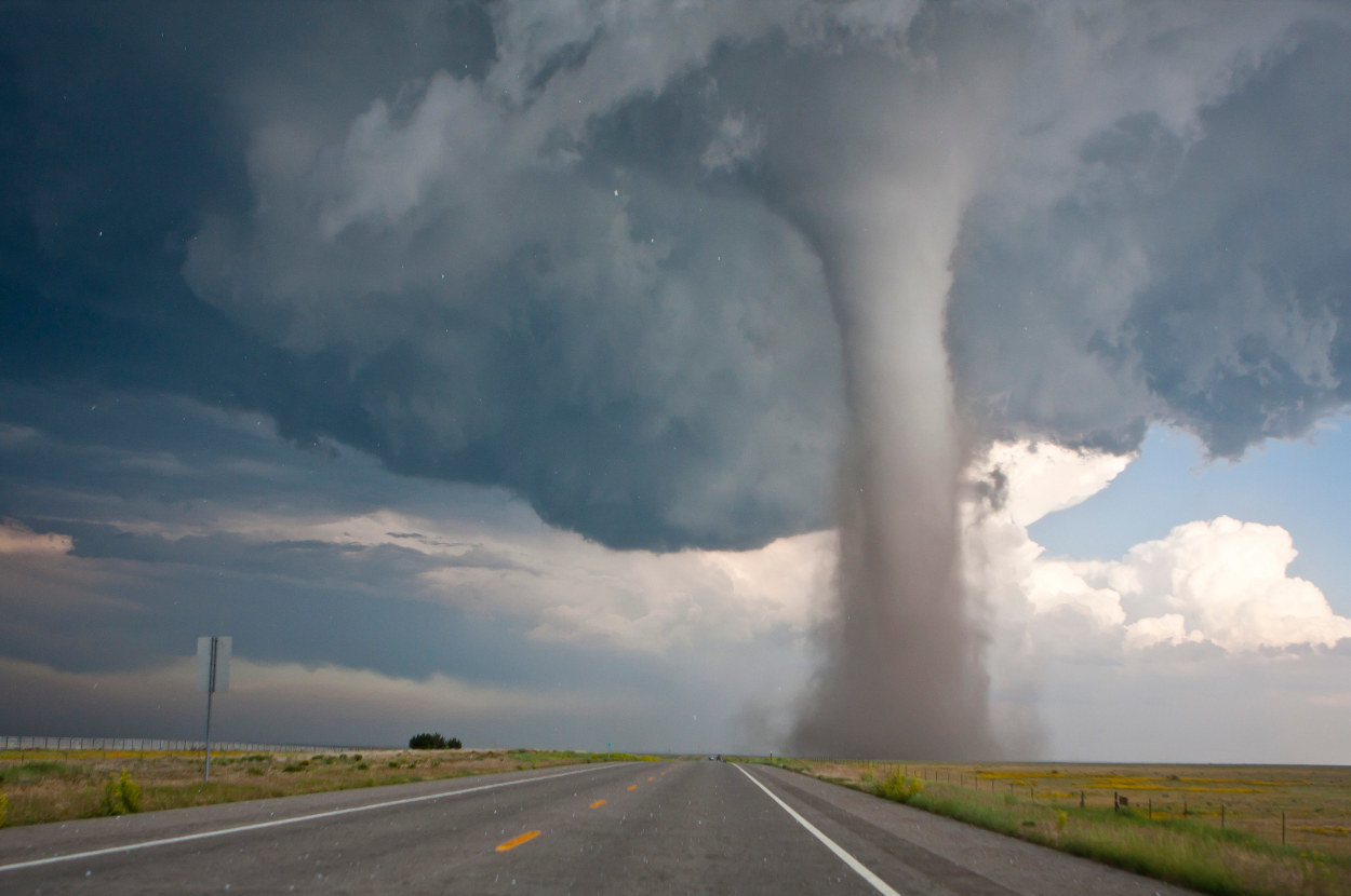 A huge tornado on the side of an empty road
