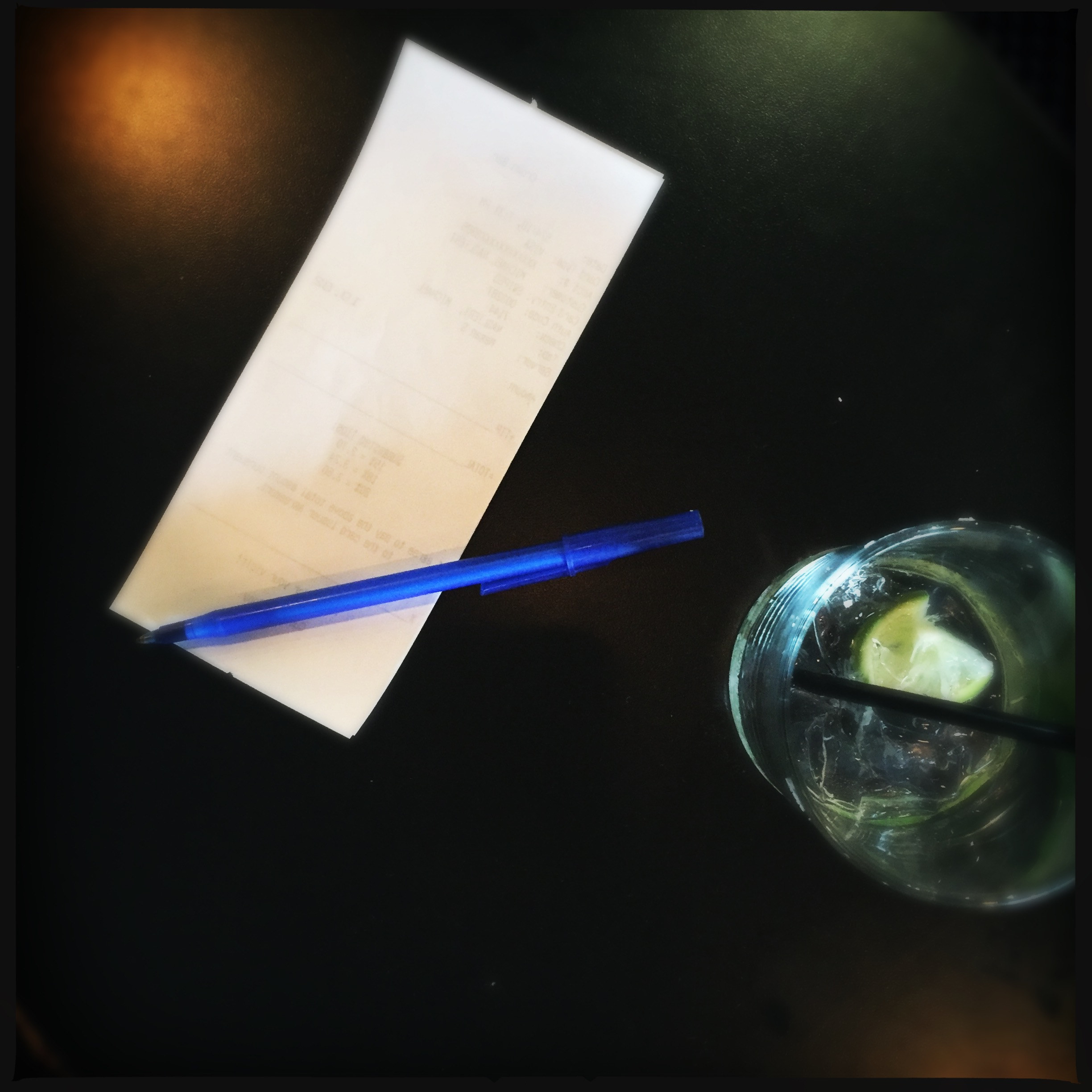 A check beside a drink on a table