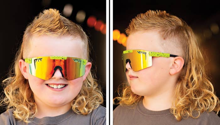 Emmitt is shown smiling for the camera with a large reflective pair of pit viper sunglasses and a flowing mullet that drapes on his shoulders