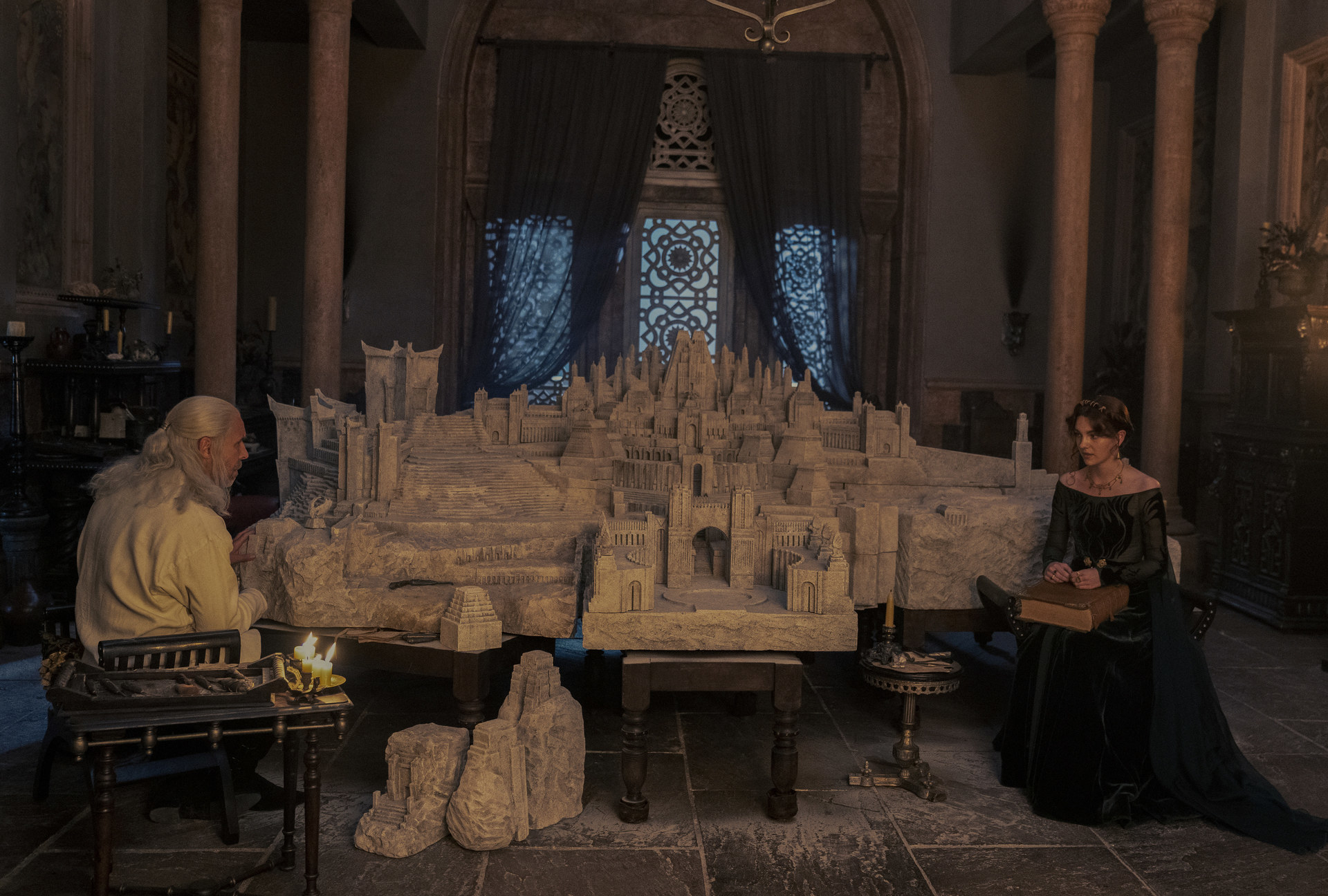 Viserys sits in front of his model Valyria with Alicent opposite him
