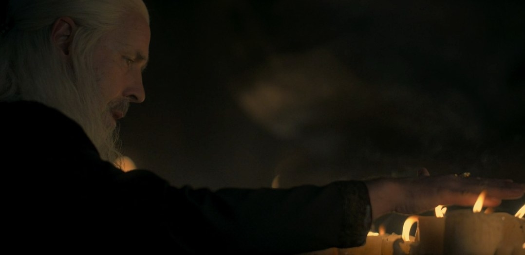 Viserys passes his hand over candle flames