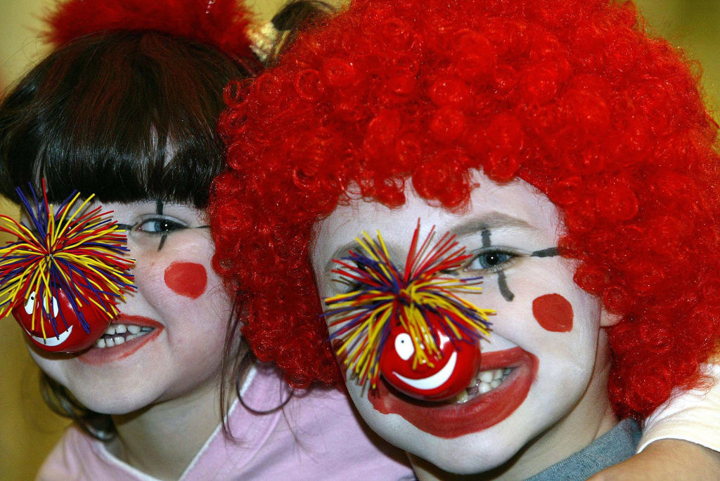 two kids with clown face paint and red noses