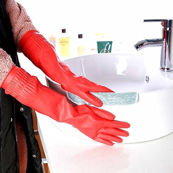 a person washing a sink while wearing the elbow-length gloves