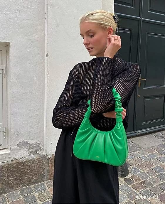 a person wearing the ruched faux leather handbag