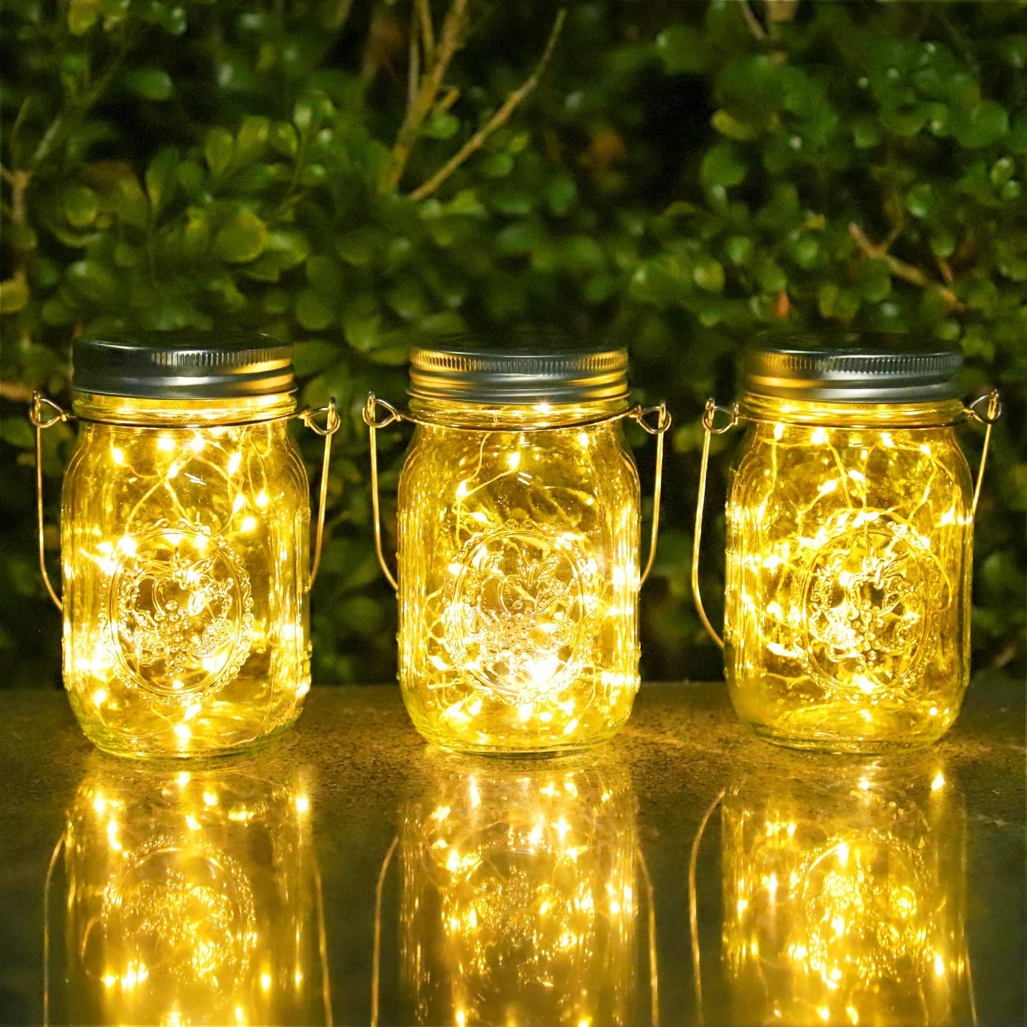 a trio of solar-powered fairy light mason jars