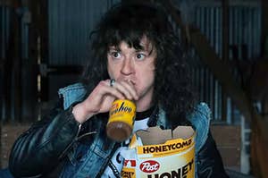 Eddie from Stranger Things drinking a Yoohoo and holding a box of Honeycomb cereal