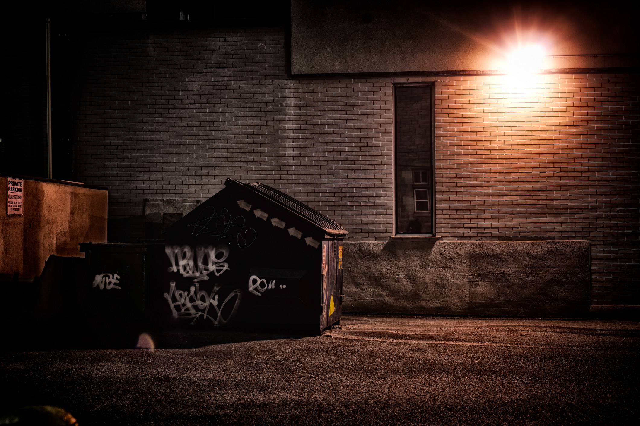 a dumpster near a building light