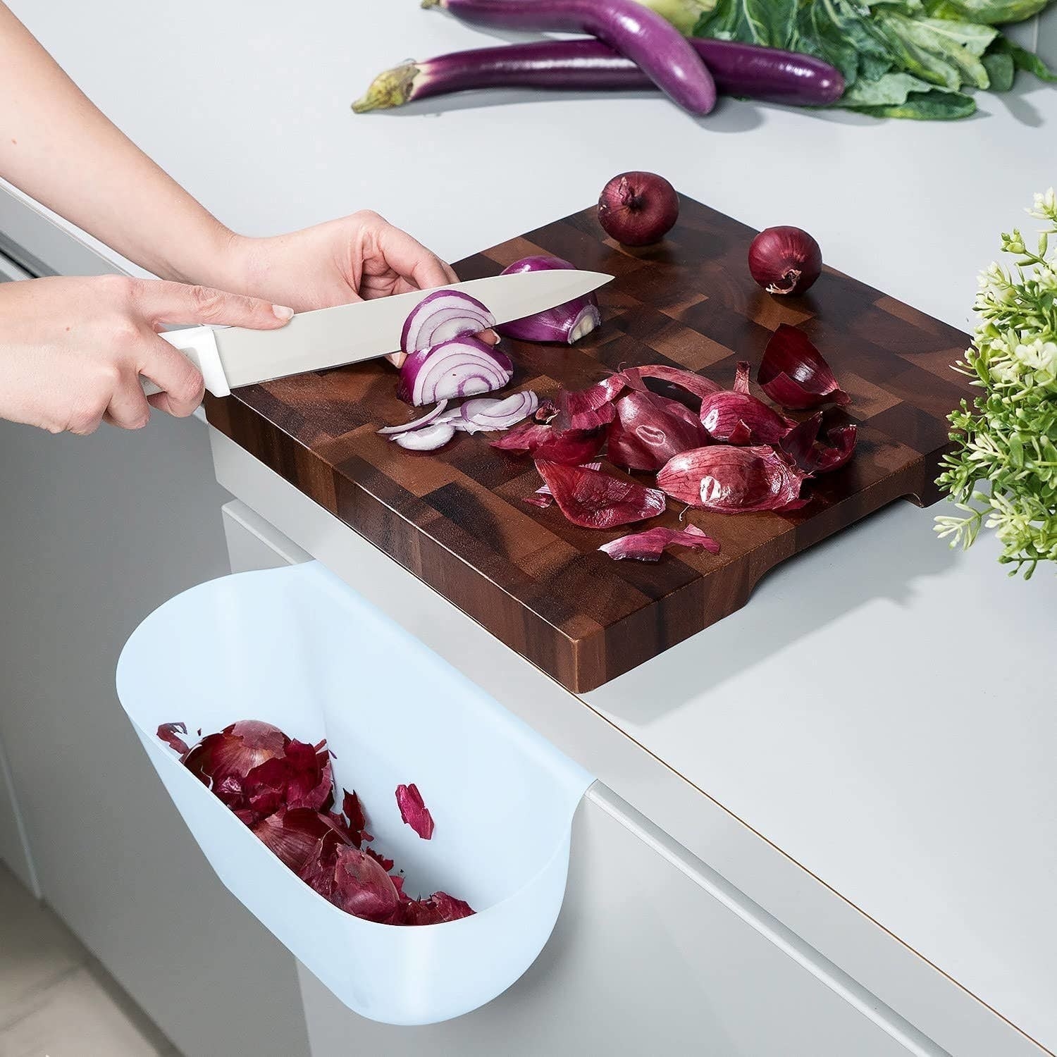 a hanging bin filled with scraps from a cutting board