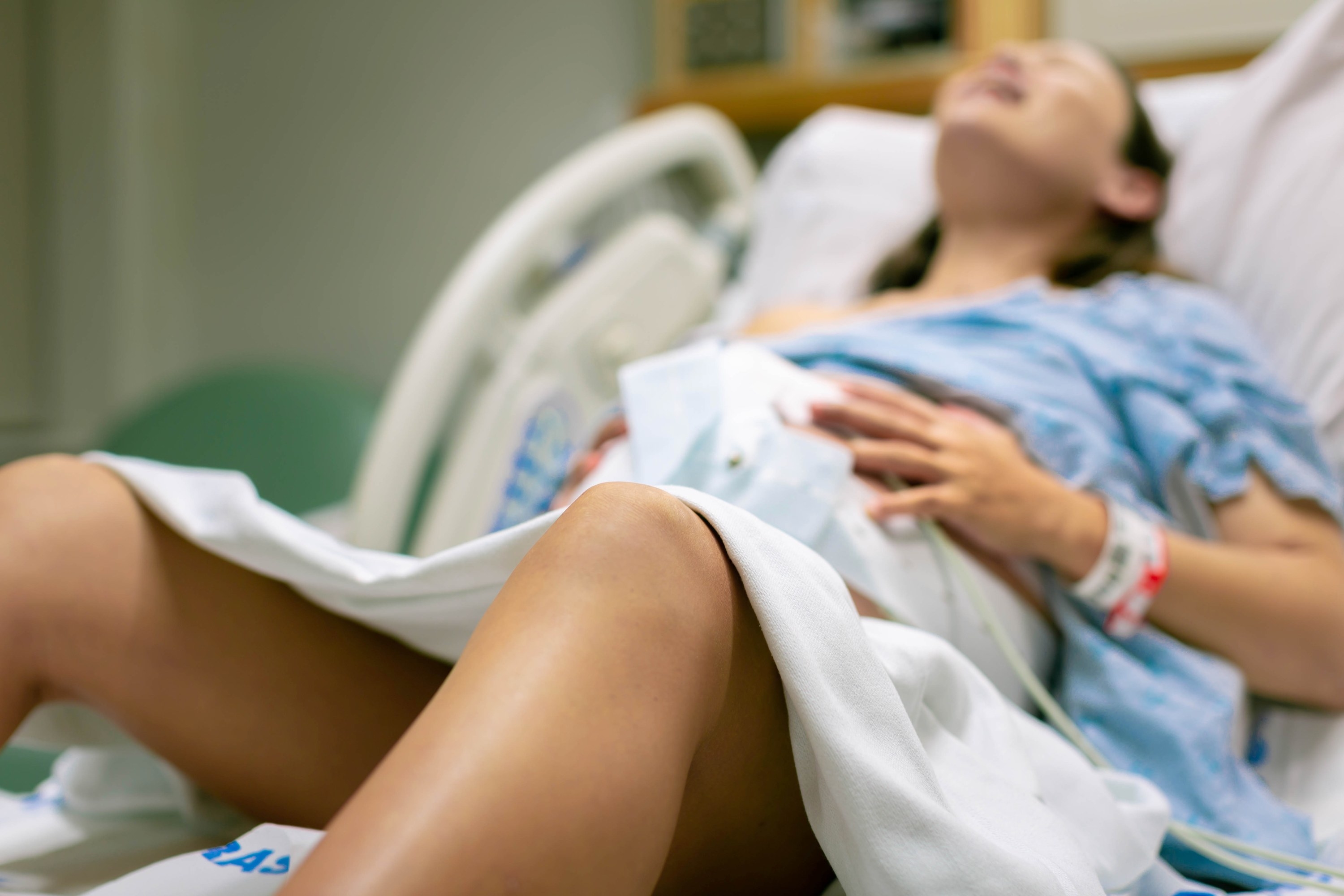 A woman screaming in pain from strong contractions during childbirth