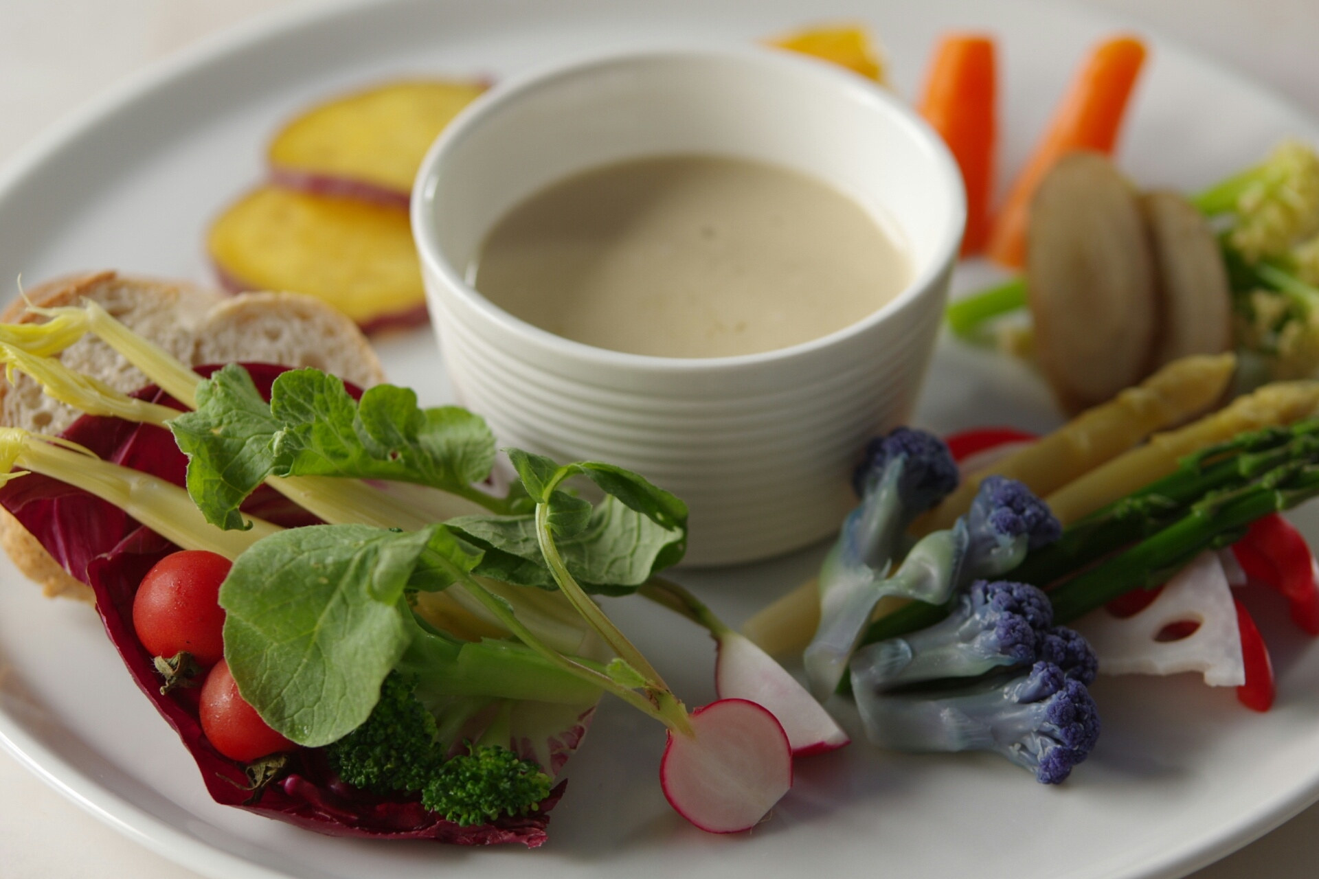 Different colorful vegetables and bagna cauda dip.