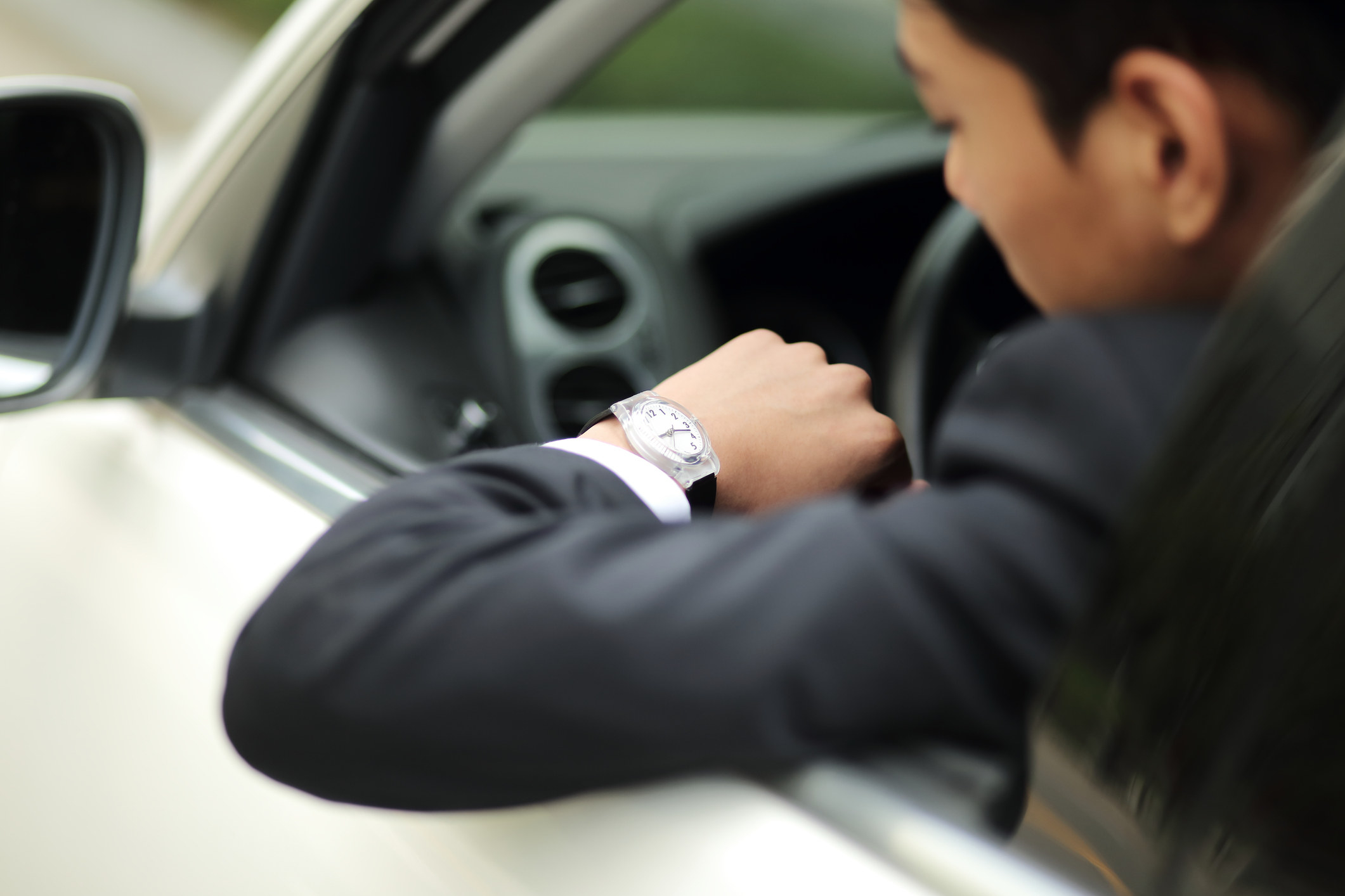 a person in the driver&#x27;s seat looking at his watch