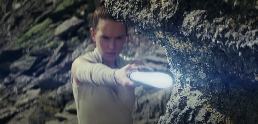 Rey with a lightsaber in a scene from The Force Awakens