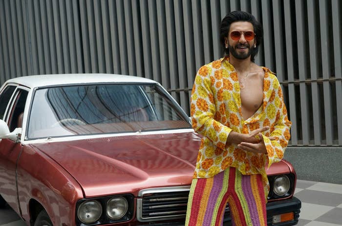 Ranveer Singh poses in front of a car