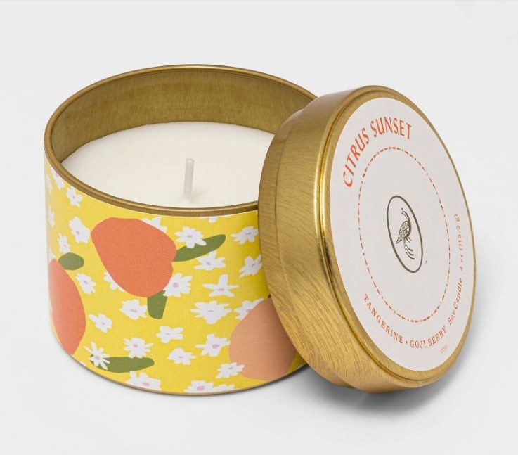 Citrus candle with lid leaning against it