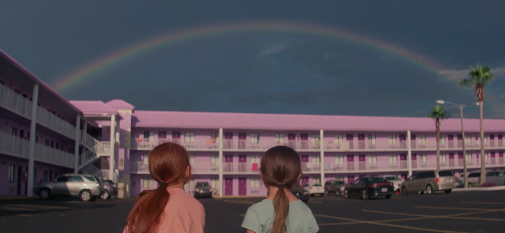 Moonee and Jancey looking at the motel with a rainbow over it in &quot;The Florida Project&quot;