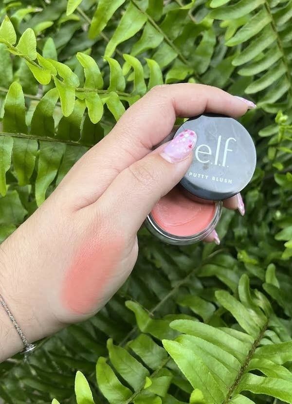 a person holding the blush showing a swatch of its colour on their hand