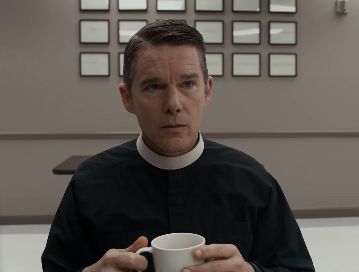 Pastor Ernst Toller holding a coffee cup in &quot;First Reformed&quot;