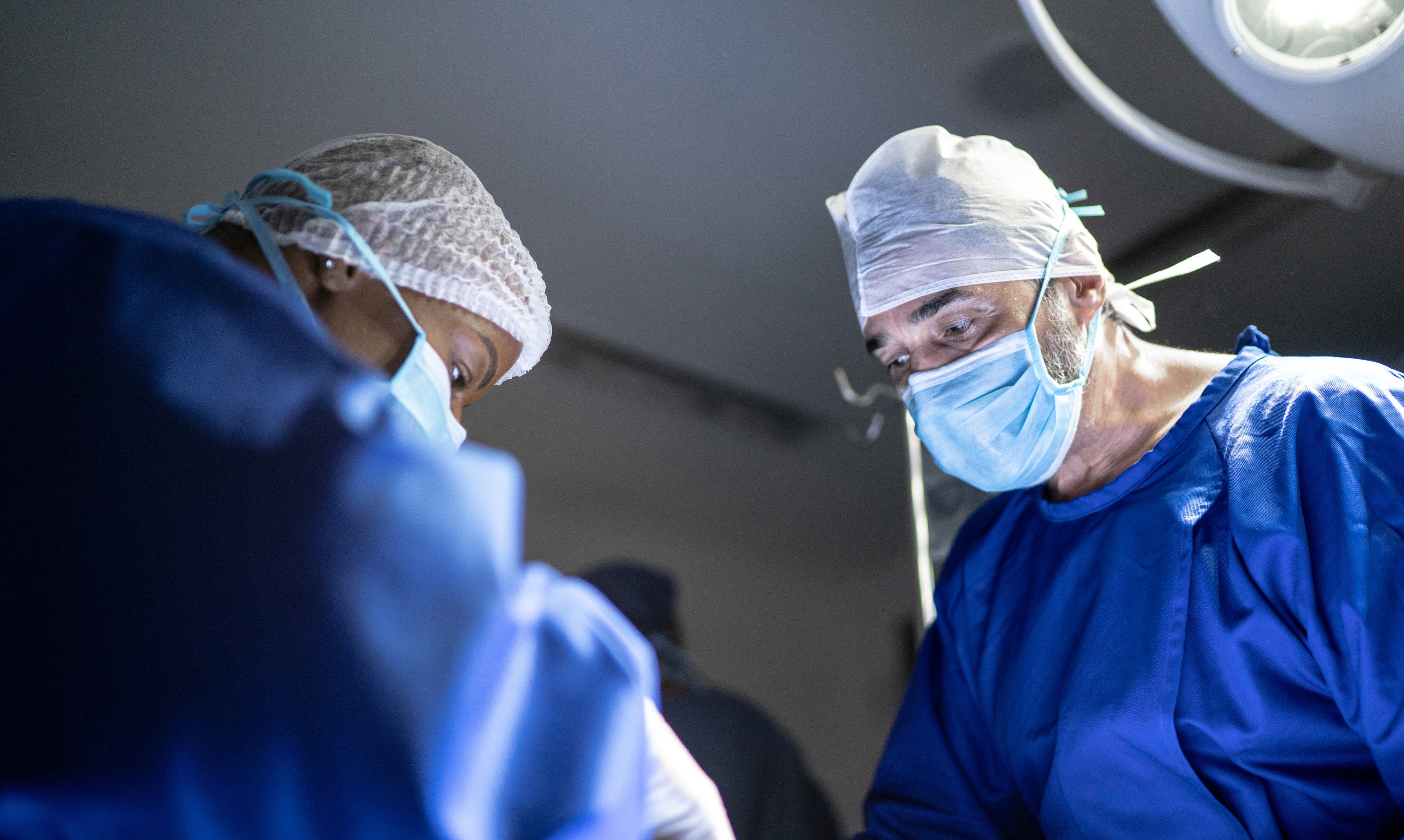 Two doctors operate on a patient