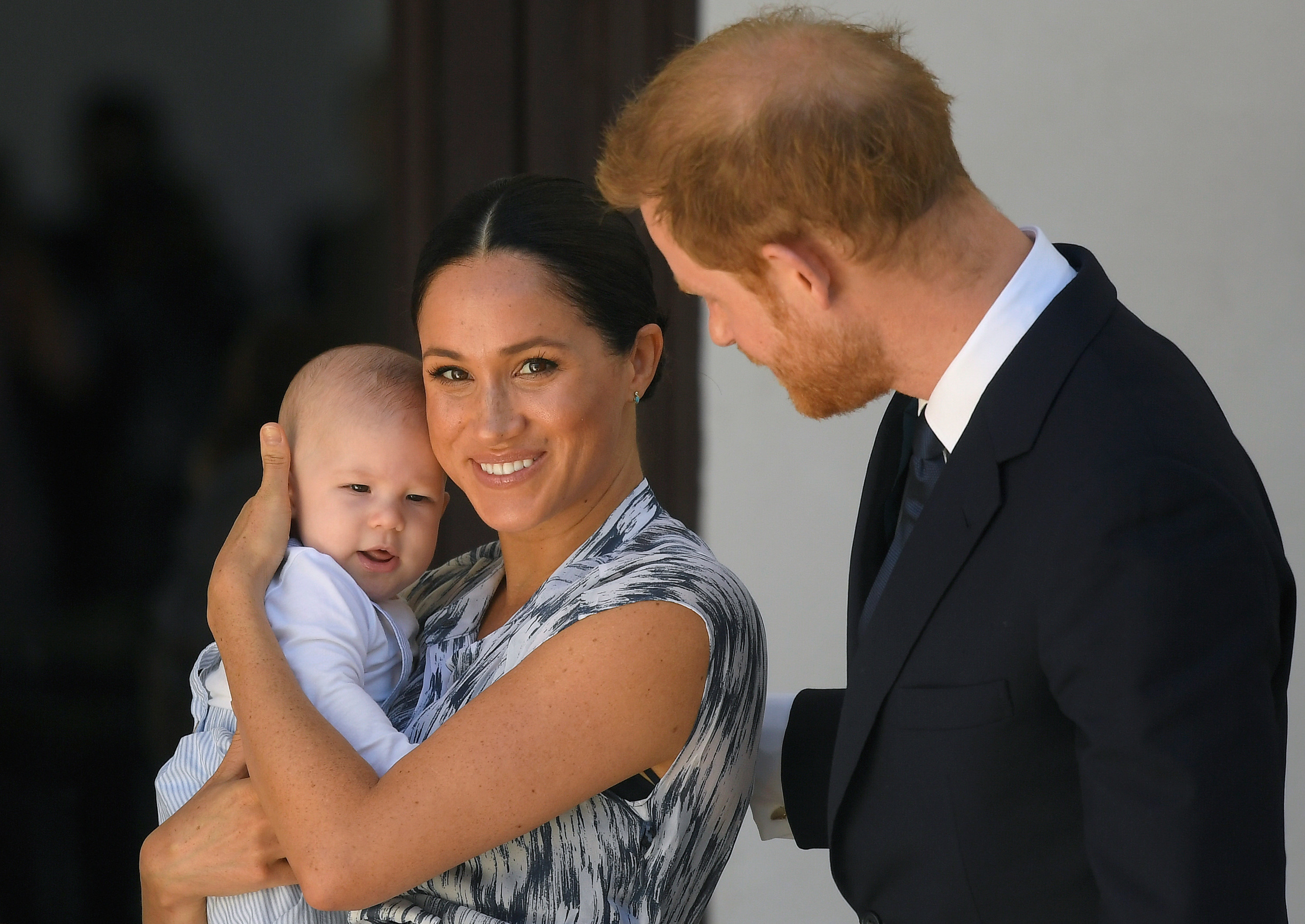 Archie in Megan&#x27;s arms as Prince Harry stands next to her