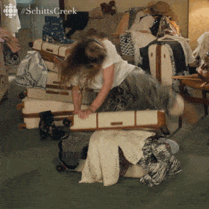 gif of alexis in schitt&#x27;s creek trying to pack a suitcase