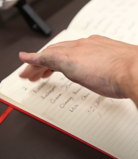 A left-handed person with ink on their hand