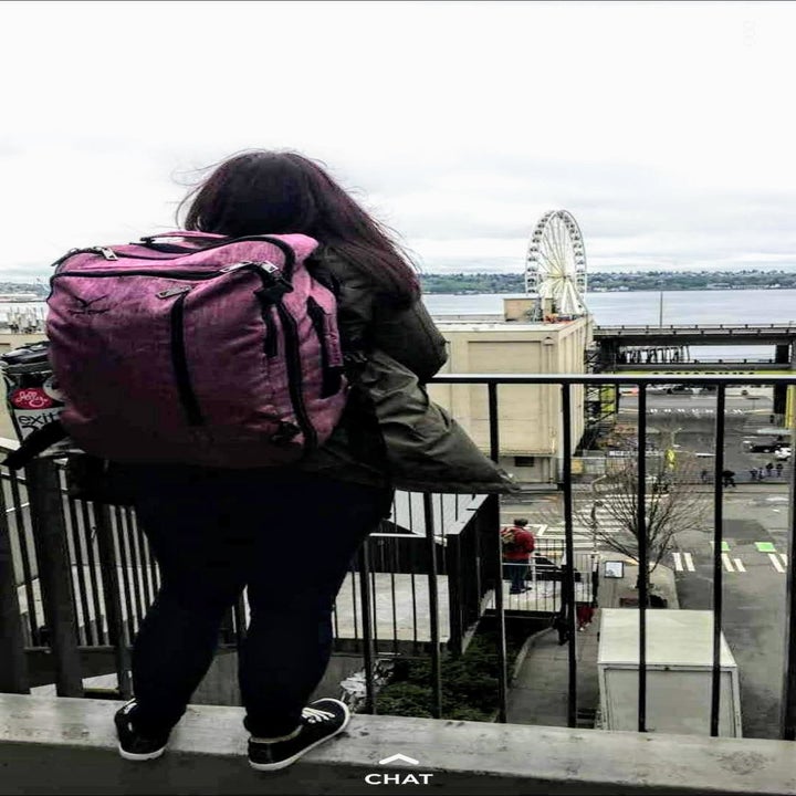 Reviewer's photo of a person wearing the backpack in the color Red Violet