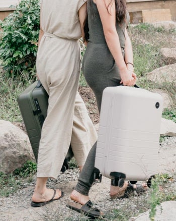Models carrying Monos Carry-On suitcases Olive Green and White