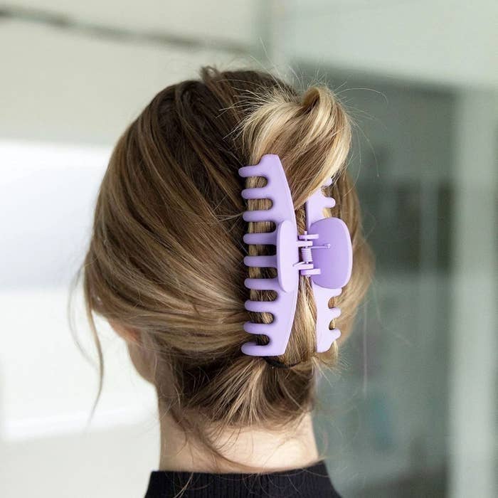 a person with a large claw clip holding their hair up