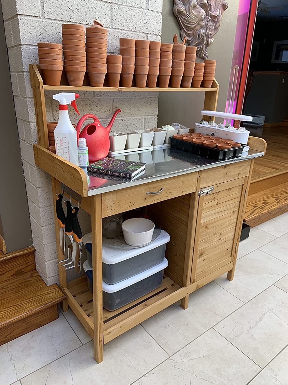 Reviewer&#x27;s potting bench is shown outside being used to store supplies
