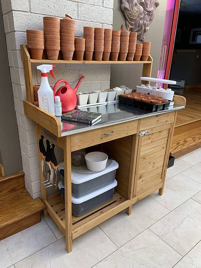 Reviewer's potting bench is shown outside being used to store supplies
