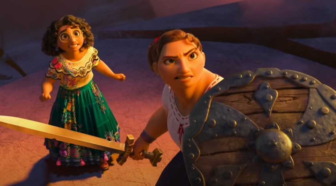 Luisa holding a sword and shield with Mirabel in the background looking nervous