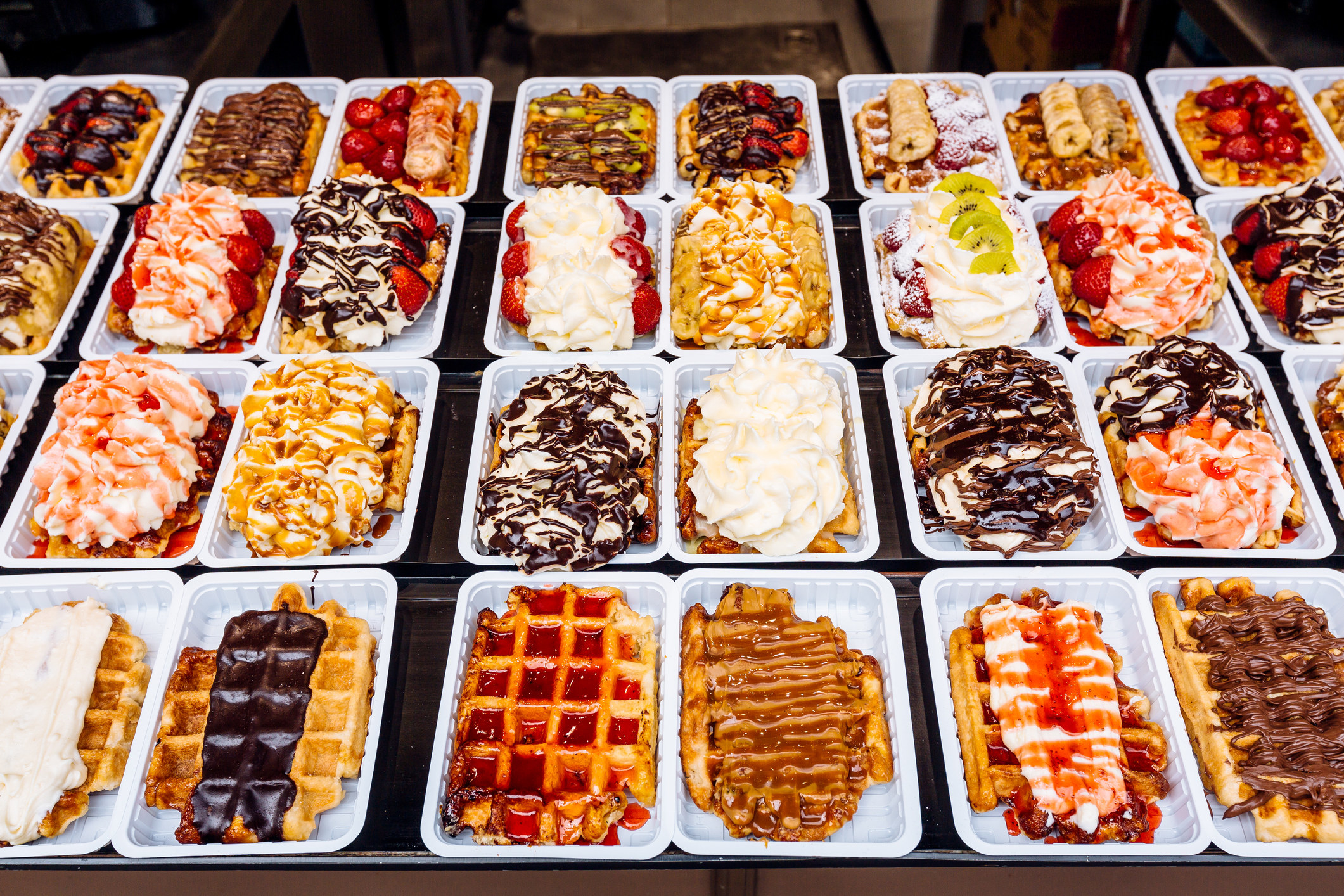 Belgian waffles with various sweet toppings for sale in Brussels.
