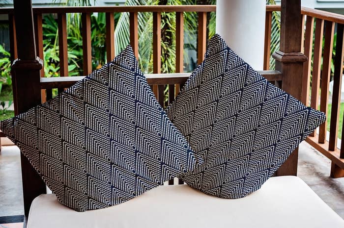 the navy and white geometric pillows on an outdoor seat