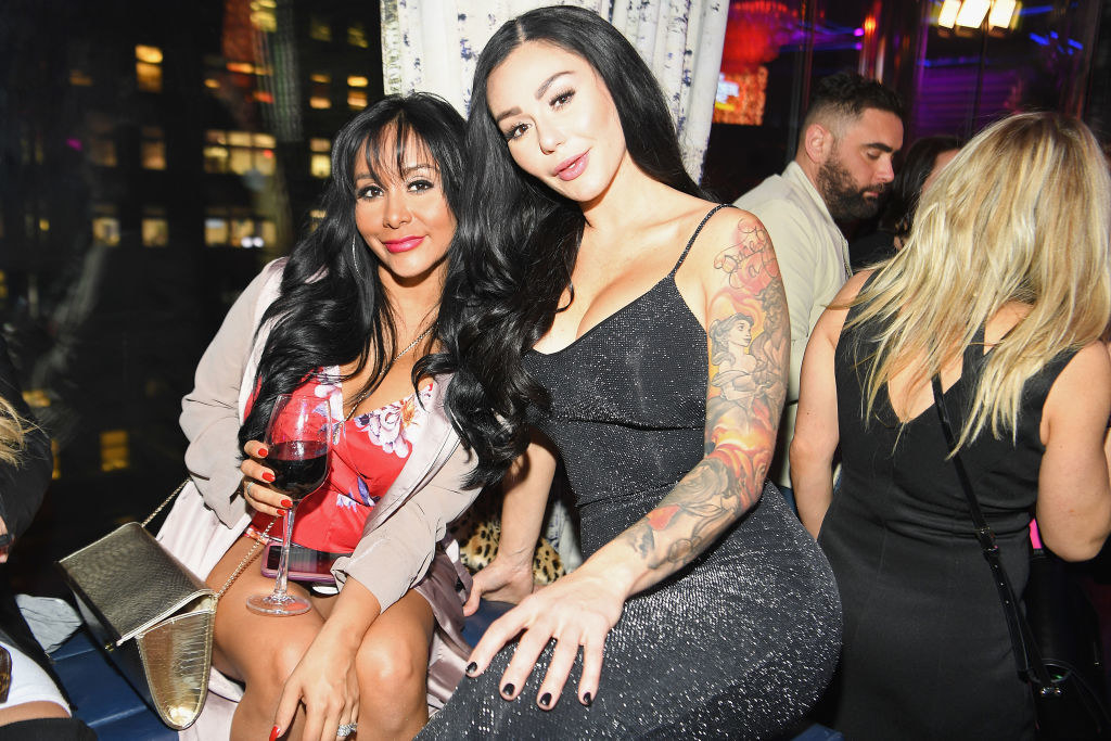 JWoww, showing the tat covering her left arm, and sitting with Snooki