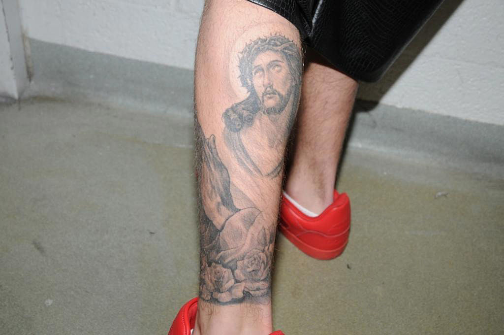 The tat of Jesus looking to the heavens covering much of the back of his left calf