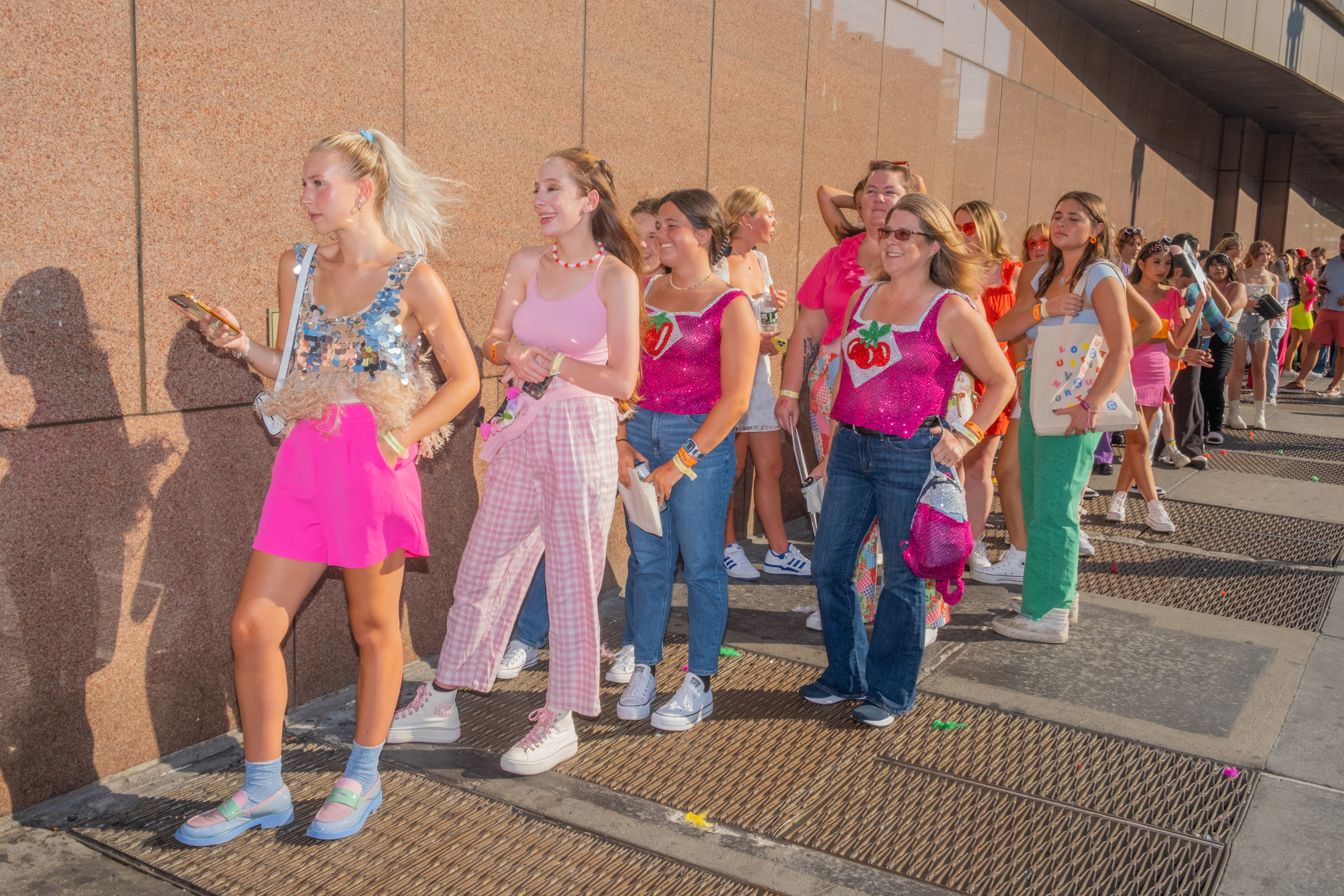 A line of people dressed in pink and other bright colors