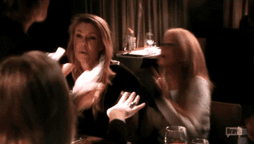 Lisa Rinna from Real Housewives of Beverly Hills throwing wine at Kim Richards and preceding to smash the wine glass on the table.