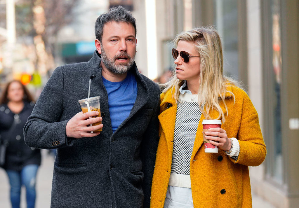 Lindsay and Ben holding coffee and walking down the street