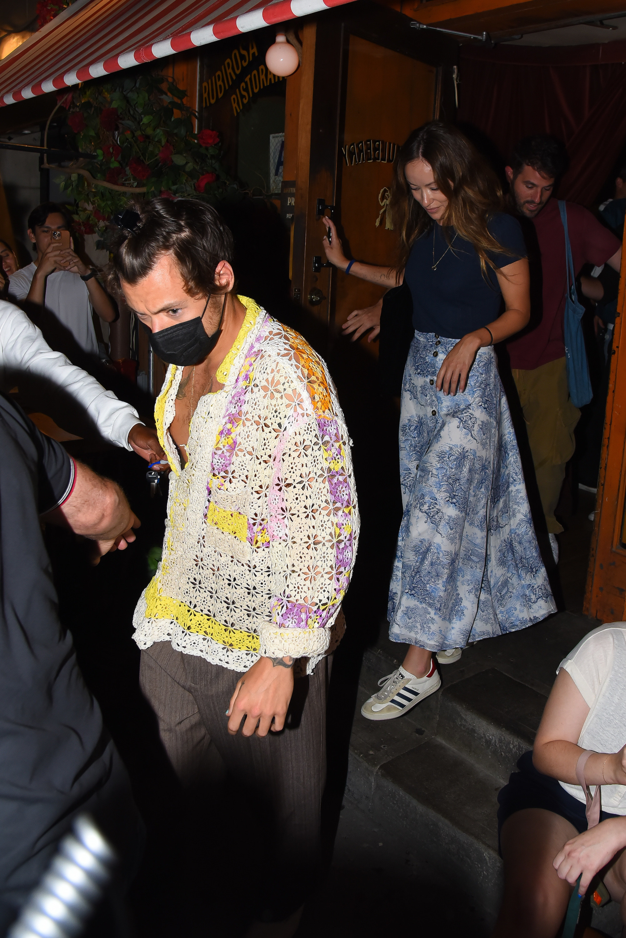 Harry and Olivia walking out of a building